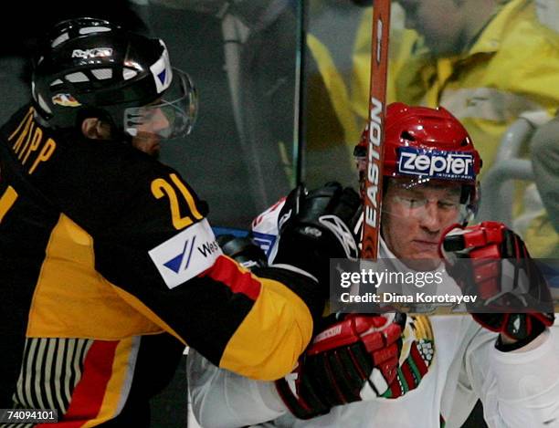 Germany's John Tripp fights for the puck with Belarus's Vladimir Denisov during the IIHF World Ice Hockey Championship qualifying round, group F...