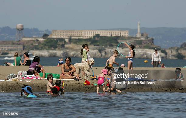 Alcatraz Island sits in the background as people play on the beach at Crissy Field May 7, 2007 in San Francisco, California. The Bay Area is...