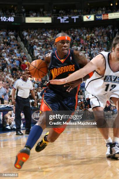 Al Harrington of the Golden State Warriors drives to the basket past Mehmet Okur of the Utah Jazz in Game One of the Western Conference Semifinals...