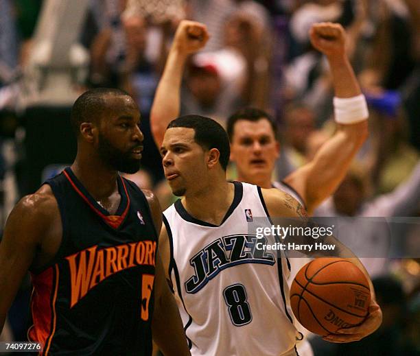 Deron Williams and Matt Harpring of the Utah Jazz celebrate a 116-112 win in front of Baron Davis of the Golden State Warriors during the fourth...