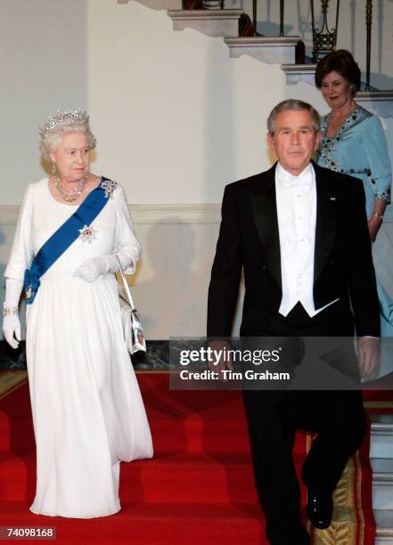 Queen Elizabeth II waks with President George W Bush and his wife Laura Bush down the White House stairs to attend a State Dinner on the fifth day of...