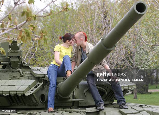 Moscow, RUSSIAN FEDERATION: A young couple kiss as they sit on a tank turret at a memorial to WW II at Poklonnaya hill in Moscow, 08 May 2007. Russia...