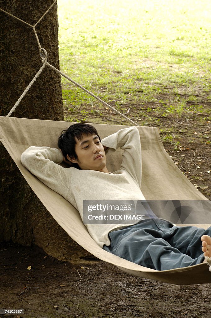 High angle view of a young man lying in a hammock