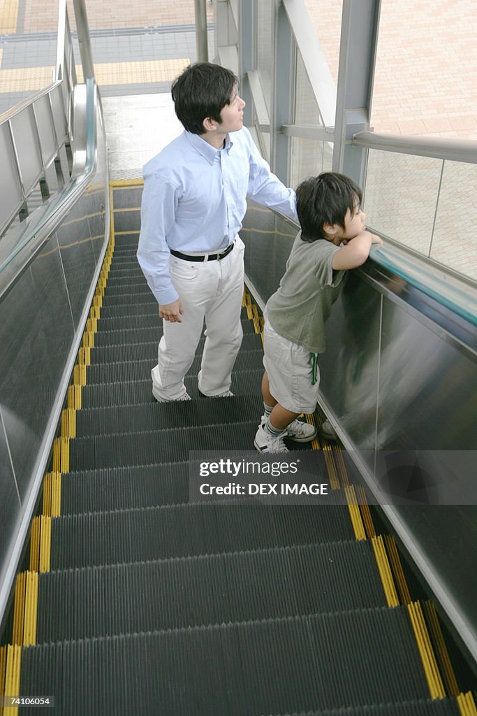 Young man and his son on an escalator