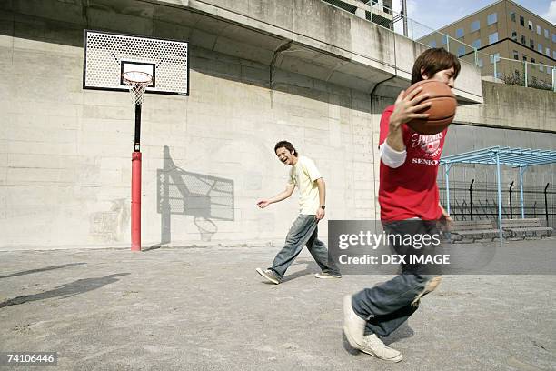 two young men playing basketball - basketball hoop pole stock pictures, royalty-free photos & images