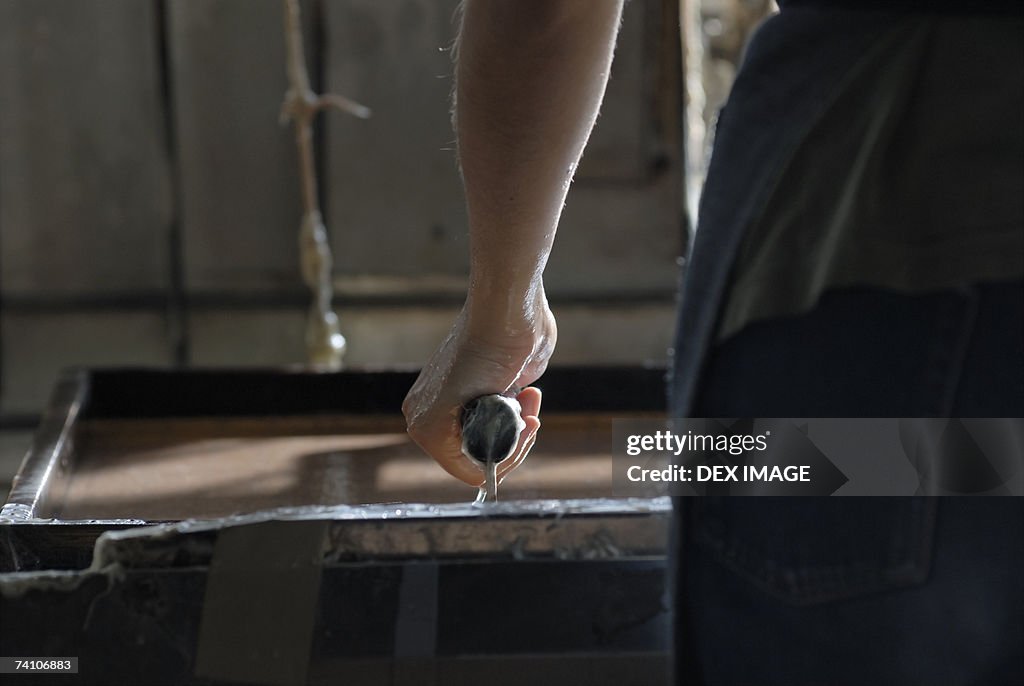 Close-up of a person's hand making a candle