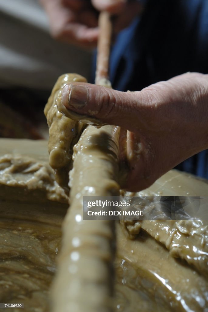 Close-up of a person's hand making a candle