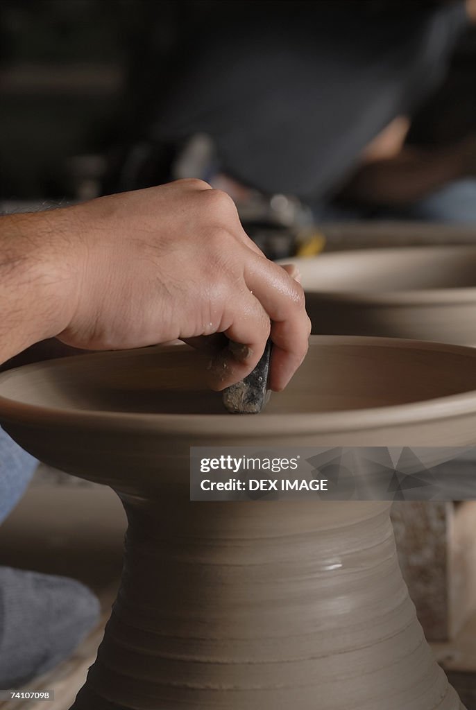 Close-up of a person's hands making pottery