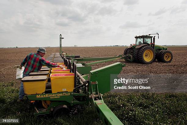 Jim Carmichael loads seed corn into a planter in a field he farms with his son May 8, 2007 near Rochelle, Illinois. More acres in the United States...
