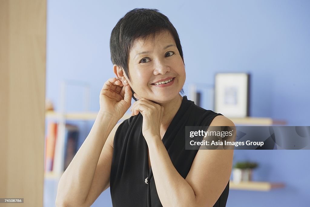 Mature woman putting on earrings