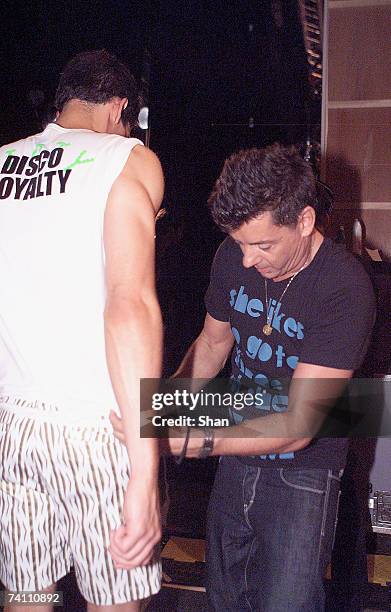 Designer Alex Zabotto-Bentley dresses one of his models backstage ahead of his FashionAssassin catwalkshow on day two of Rosemount Australian Fashion...