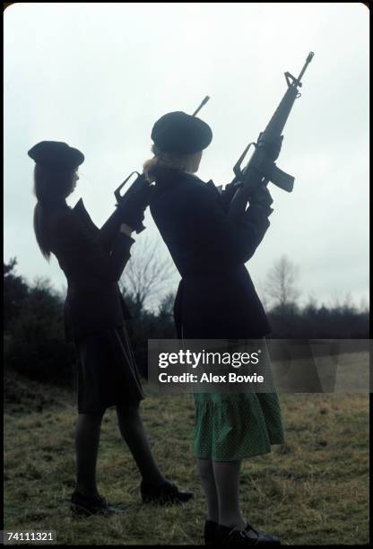 Girls with M16 rifles pose during a training and propaganda exercise in Northern Ireland, 12th February 1977.