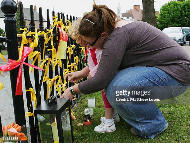 Young girl, Leah Breckenridge, and her mum, Claire Kasher of Rothley, tie a Ribbon of support to railings in the village centre of Rothley on May 9,...