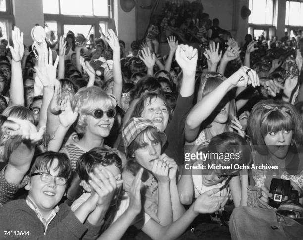 Screaming fans cheer for rock and roll musicians on American Bandstand in the mid 1960's.