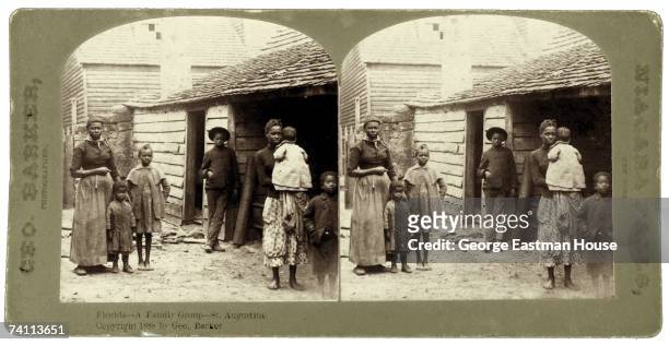 Stereoscopic image shows a portrait of a poor family as they stand near their home, St. Augustine, Florida, 1888.