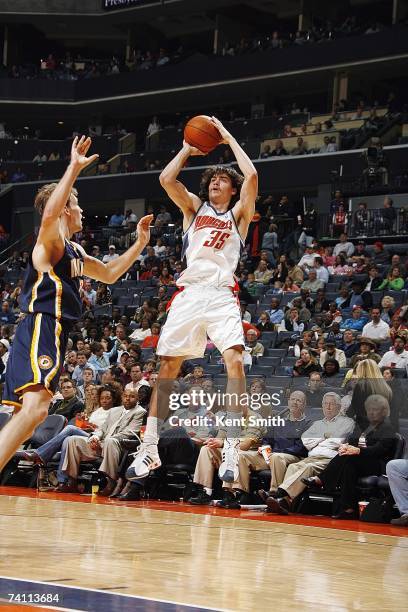 Adam Morrison of the Charlotte Bobcats takes a jump shot past Mike Dunleavy of the Indiana Pacers on April 6, 2007 at Charlotte Bobcats Arena in...