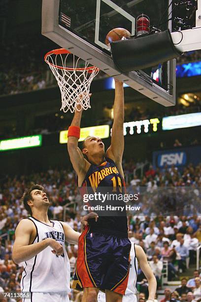 Andris Biedrins of the Golden State Warriors goes to the basket over Mehmet Okur of the Utah Jazz in Game One of the Western Conference Semifinals...