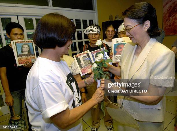 Former Philippine president Corazon Aquino , a widower of a political killing, receives white roses from members of human rights group Families of...