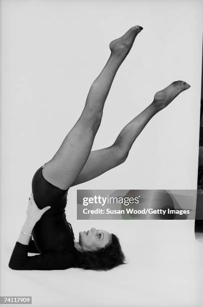 Profile portrait of Belgian-born American fashion designer Diane von Furstenberg in a yoga pose with her legs in the air, June 16, 1977.