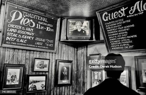 Her Majesty The Queen of England seen making an announcement on a television inside a London pub, during the public funeral of Diana, Princess of...