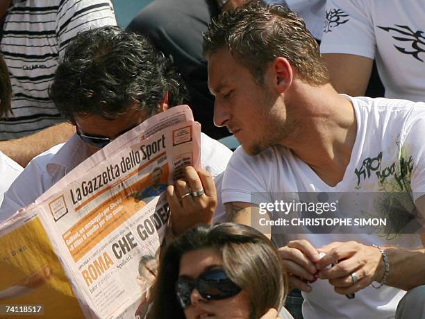 Italian AS Roma captain Francesco Totti looks at Italian sport newspaper La Gazzetta dello Sport in the tribune during the tennis match between...