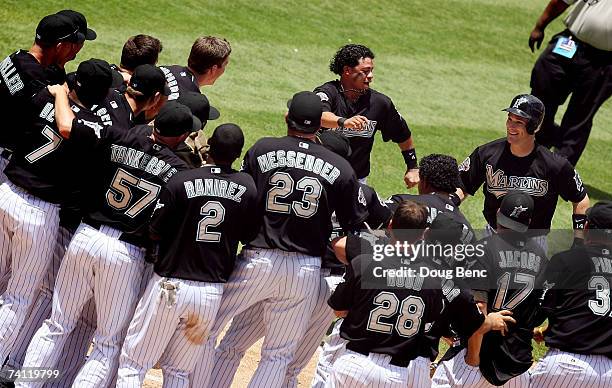 Josh Willingham of the Florida Marlins celebrates with teammates as he prepares to cross home plate after hitting a three-run home run in the bottom...