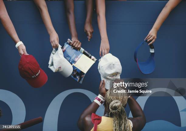 Serena Williams of the United States signs autographs for her fans after defeating Martina Sucha their Women's Singles third round match at the US...