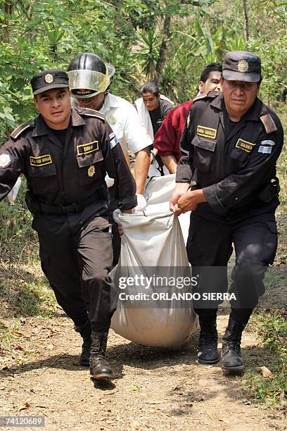 Agentes de la Policia Nacional Civil cargan una bolsa con los restos de una joven asesinada en el municipio de San Pedro Ayampuc al norte de Ciudad...