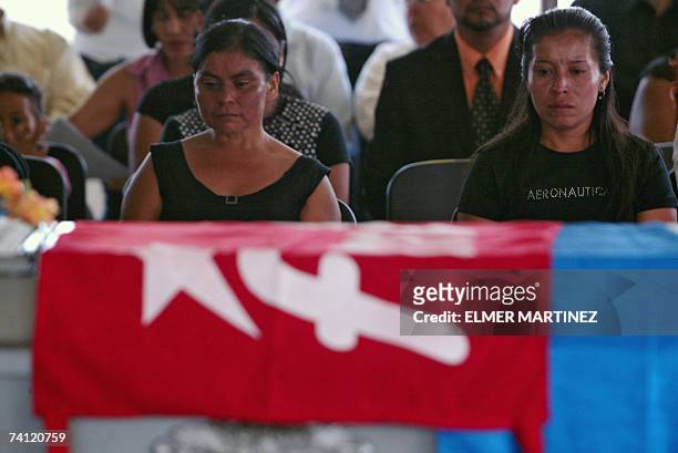 Tegucigalpa, HONDURAS: Reina Sanchez y Milagros Sanchez velan a su hermano Juan Humberto Sanchez, cuyo feretro esta cubierto con la bandera del...