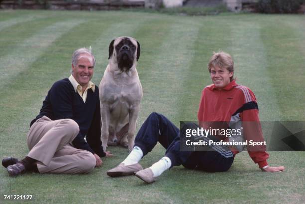Swedish tennis player Stefan Edberg pictured sitting with his tennis coach Tony Pickard and a large dog on a garden lawn at a house in England in...