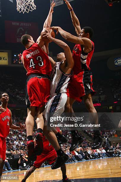 Richard Jefferson of the New Jersey Nets gets denied as he goes to the basket against Kris Humphries and Joey Graham of the Toronto Raptors in Game...