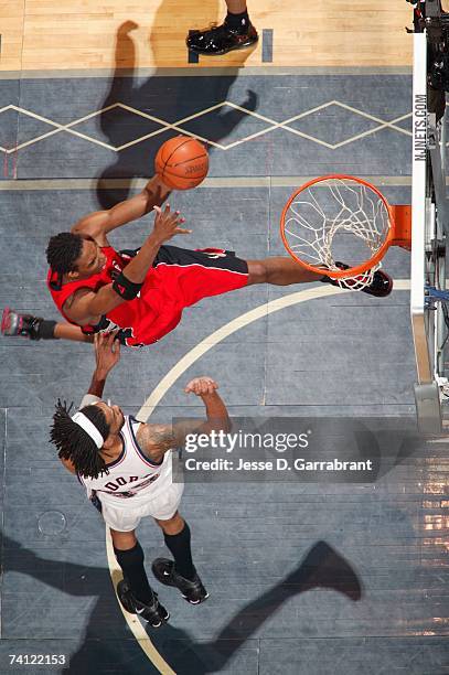 Chris Bosh of the Toronto Raptors drives to the basket for a layup against Mikki Moore of the New Jersey Nets in Game Six of the Eastern Conference...