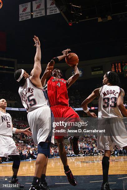 Chris Bosh of the Toronto Raptors goes up for a shot against Jason Collins and Mikki Moore of the New Jersey Nets in Game Six of the Eastern...