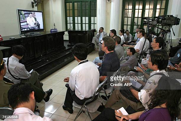 Foreign media and diplomats watch the trial of two Vietnamese dissident lawyers via closed circuit television at the People's Court in Hanoi, 11 May...