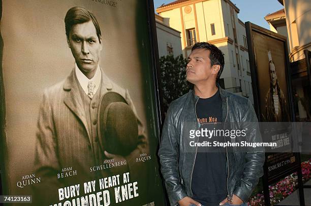 Actor Adam Beach poses with the movie poster featuring his picture at the Los Angeles premiere of HBO's "Bury My Heart At Wounded Knee" at Paramount...