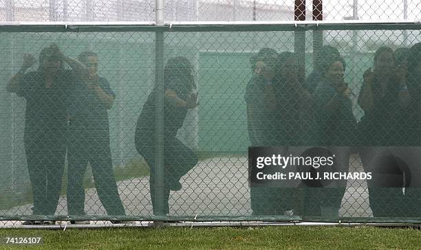 Raymondville, UNITED STATES: Female detainees stand at the fence in the exercise yard inside Homeland Security's Willacy Detention Center, a facility...