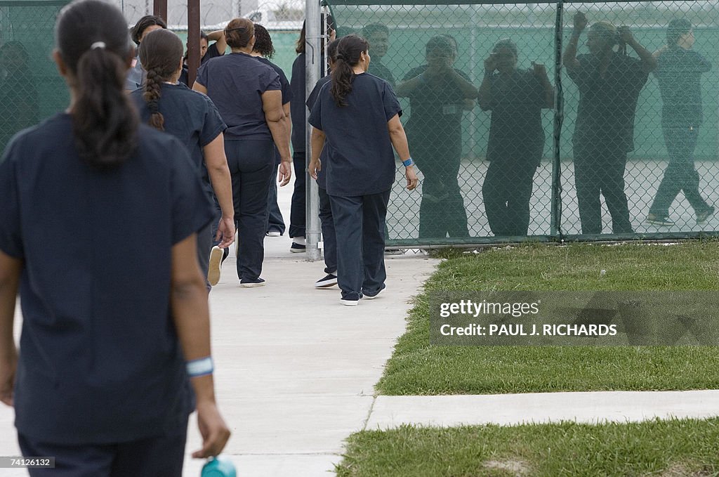 Female detainees walk to the exercise ya...