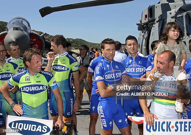 Italy's Olympic and World cycling champion Paolo Bettini with his daugther Veronica looks at Danilo Di Luca , surrounded by their teammates on the...