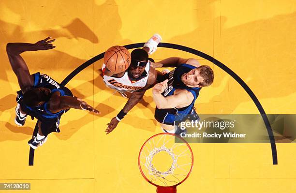 Stephen Jackson of the Golden State Warriors shoots a layup against DeSagana Diop and Dirk Nowitzki of the Dallas Mavericks in Game Six of the...