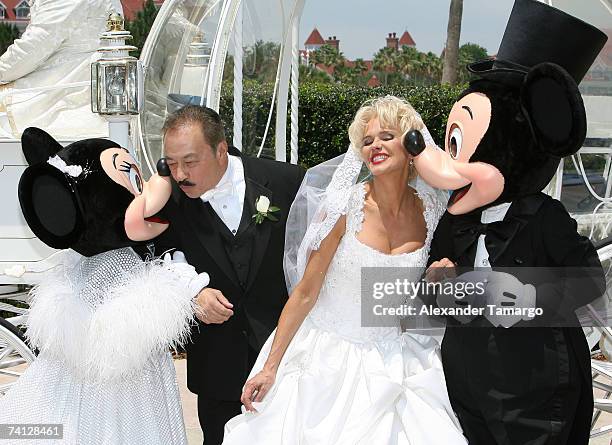 Charytin Goyco and husband Elin Ortiz share a kiss with Mickey and Minnie after Charytin Goyco's dream wedding at Walt Disney World at the Grand...