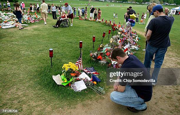 Man who did not want to be identified pauses to pray in front of a small pile of flowers, candles and other mementos left for Virginia Tech shooter...