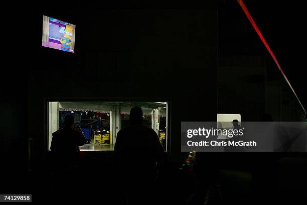 Time shot 8.01 pm Straggler spectators peer through viewing windows into empty garages as "The Simpsons" plays on a television monitor after the...