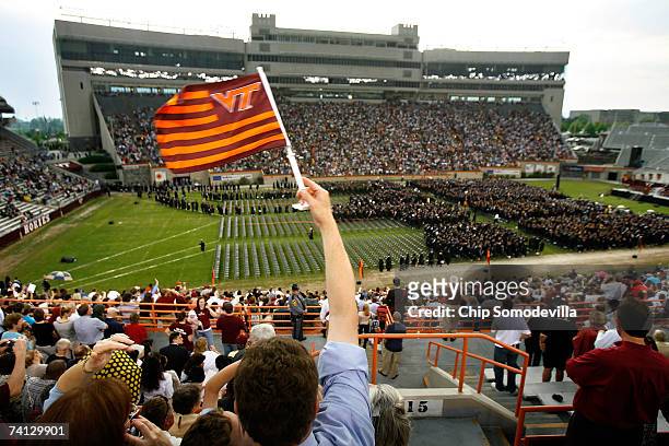 Virginia Tech flag is waved as about 2,500 graduates file into the commencement ceremony at Lane Stadium on the Virginia Tech University campus May...