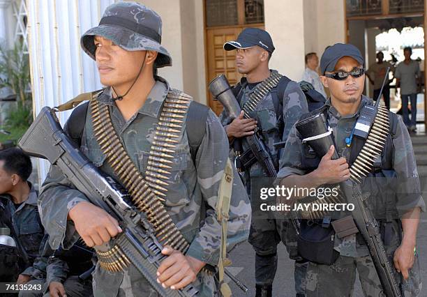 Policemen with M-60 machine gun guard the perimeter of the municipal hall in Abra, in the northern Philippine province, 13 May 2007. Security remains...
