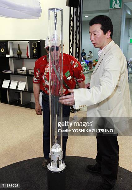 Visitors take a closer look at Japan's electronics giant Sony's prototype model of transparent pole speaker system "Rin", which renders stereo sound...