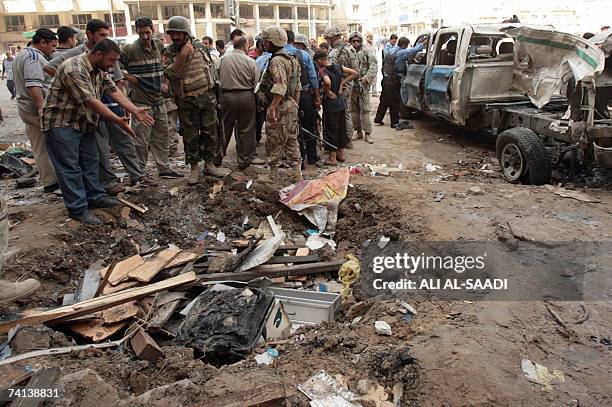 An Iraqi shows police a huge crater at the site of a powerful explosion which erupted 13 May 2007 in a central Baghdad market, ripping through a...