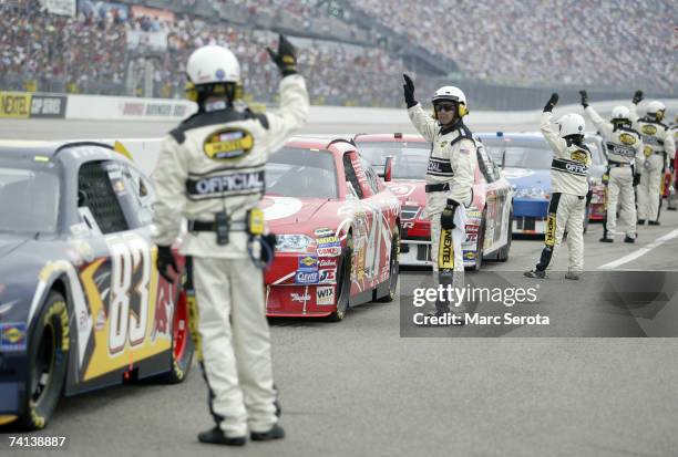 Officals hold up their hands to signal that the drivers are ready to start the race, prior to the NASCAR Nextel Cup Series Dodge Avenger 500 on May...