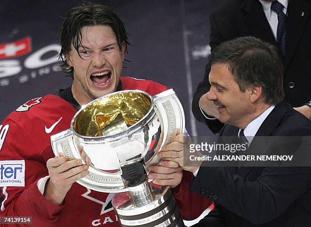 Moscow, RUSSIAN FEDERATION: The President of the International Ice Hockey Federation Rene Fasel handles the trophy to Canadian Shane Doan after the...