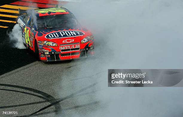 Jeff Gordon, driver of the DuPont Chevrolet, does a burnout after winning the NASCAR Nextel Cup Series Dodge Avenger 500 on May 13, 2007 at...