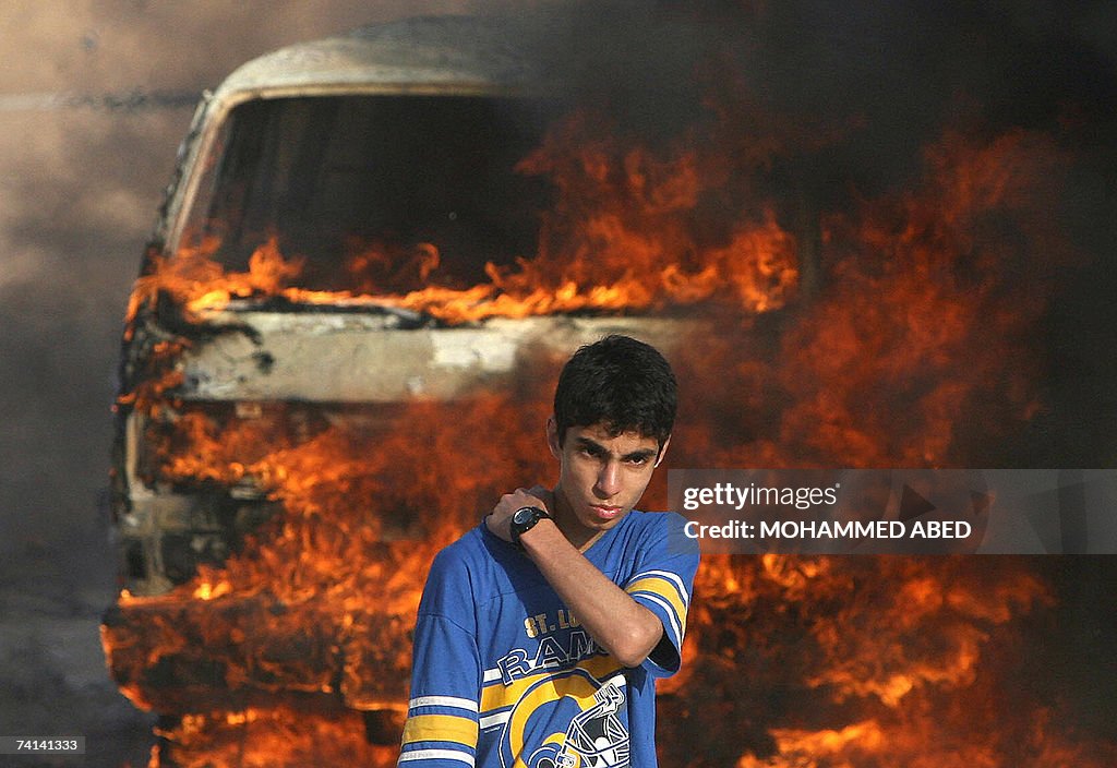 A Palestinian youth stands in front of a...